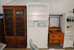 A white painted bookcase with cupboard base