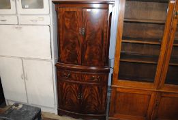 A reproduction mahogany drinks cabinet raised on cupboard base with single drawer