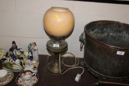 A brass oil lamp with glass shade converted to ele