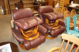 A pair of leatherette swivel armchairs and footsto