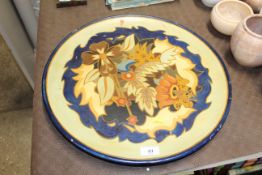 A Longpark floral decorated terracotta charger with floral decoration