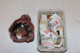A box containing various loose stamps and a bowl o
