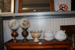 Two oil lamps together with three glass light shad