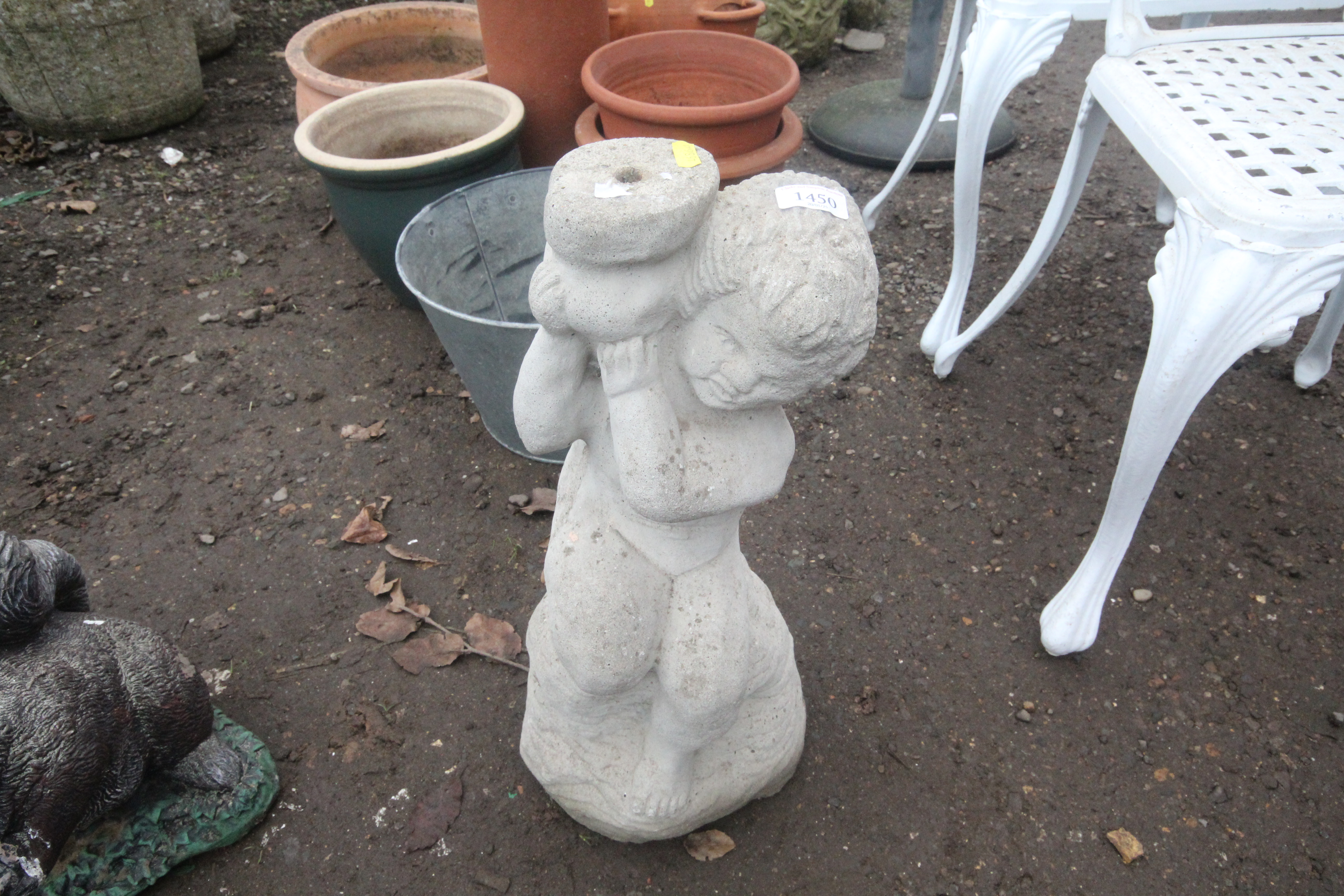 A statue of a seated child holding a water jug