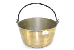 A large brass jam pan with metal swing handle