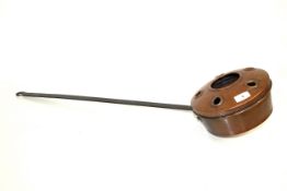 A copper chestnut roaster with long steel handle
