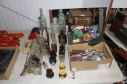 An oak case two hole mantel clock, a collection of old bottles, quantity of various cutlery, a