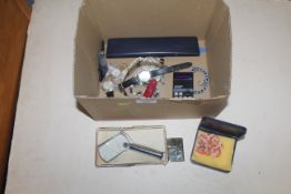 A box containing various wrist watches, a reading glass, Sinclair calculator, a Tiger lighter etc.