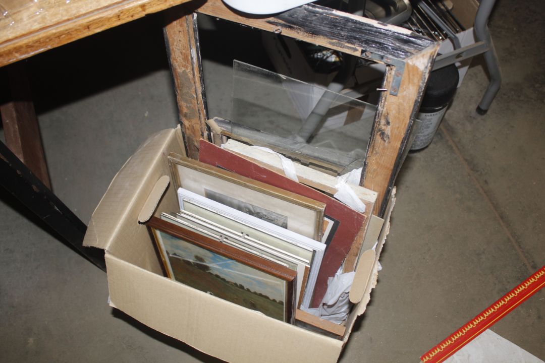 A box containing various picture frames and prints