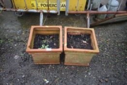 A pair of terracotta plant pots, of square form