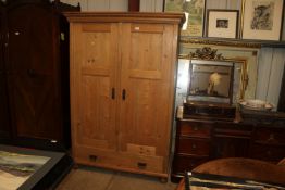 A stripped pine two door wardrobe fitted single dr