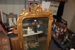 A gilt framed bevel edged wall mirror decorated wi