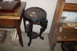 An oriental plant stand with lion mask decoration