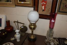 A brass oil lamp with milk glass shade and glass c