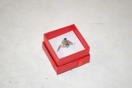 A vintage white metal ruby, diamond and emerald set ring, size O/P
