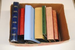 A box of various postcard albums containing postcards from the early 1900s through to 1990
