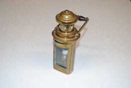 A brass handheld lamp with swing handle
