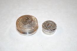 Two circular silver pill boxes