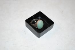 A vintage white metal ring set with coloured stone