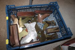 A plastic crate containing various brass fire plac