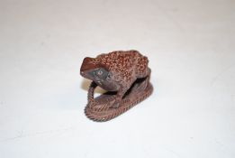 A wooden Netsuke in the form of a frog