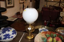 A brass oil lamp with opaque glass shade