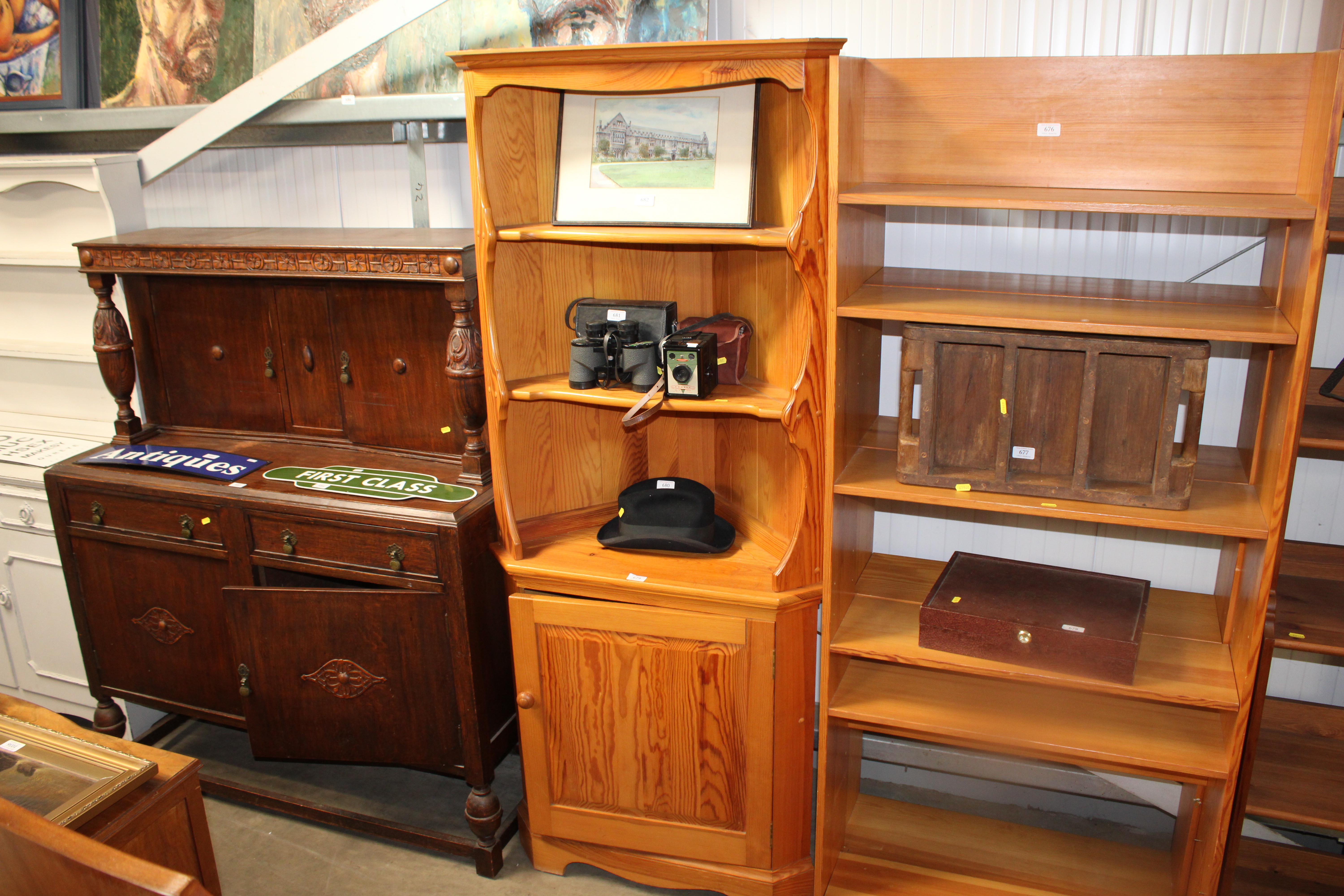 A light Ercol corner unit raised on cupboard base