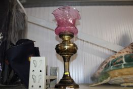 A brass Corinthian column oil lamp having cranberr