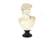 A white glazed classical bust of David, raised on a  black socle base, 53cm high