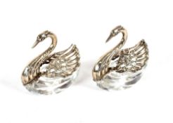 A pair of cut glass and silver mounted salts, in the form of swans, with hinged folding wings