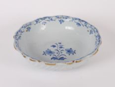 A blue and white Delft ware bowl, having shaped border and fluted body decorated foliate sprays,