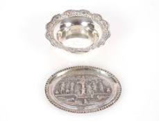 A Continental white metal shallow oval pin dish, decorated with dancing figures around a serpent and