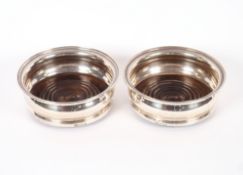 A pair of 20th Century silver coasters, having turned wooden bases, Birmingham 1968, 14.5cm dia.