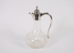 A Victorian cut glass baluster claret jug, silver mounted with domed hinged lid and scroll handle,