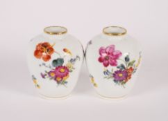 A pair of 19th Century Continental porcelain posy vases, the foliate spray decoration heightened