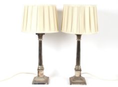 A pair of plated Corinthian column table lamps, complete with pleated silk shades 74cm high