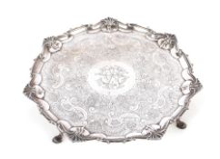 An Edwardian silver salver, having pie crust and shell decorated border, foliate scroll field and