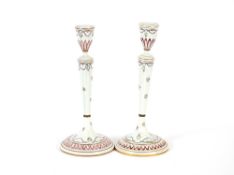 A pair of 19th Century Continental porcelain candlesticks, having enamelled floral decoration,