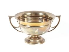 A George V silver trophy, flanked by foliate scroll handles, raised on a circular spread foot by