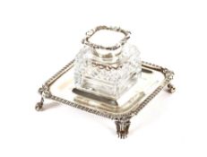 A late Victorian silver and hobnail cut glass inkwell, raised on a square gadrooned and foliate