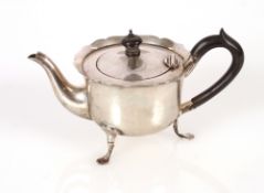 A late Victorian silver bachelors tea pot, having serrated border and black wood handle and lift,