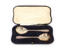 A cased pair of silver fruit servers, having foliate and ribbon tied terminals, London 1929, 130.