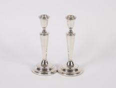 A pair of silver candlesticks, having filled bases, London 1984, 19cm high