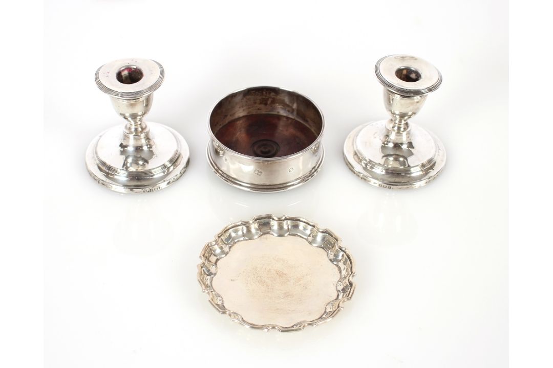A pair of silver dwarf candlesticks, Birmingham 1905, with loaded bases AF, 9cm high; a silver pie