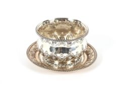 A late Victorian silver sugar bowl on stand, having raised foliate decoration and gadrooned borders,