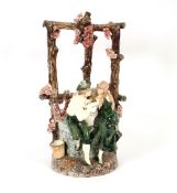 A large Continental pottery table centrepiece, in the form of a courting couple sat around a well,