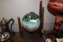 A Lynne Taylor, green glazed pottery sphere on woo