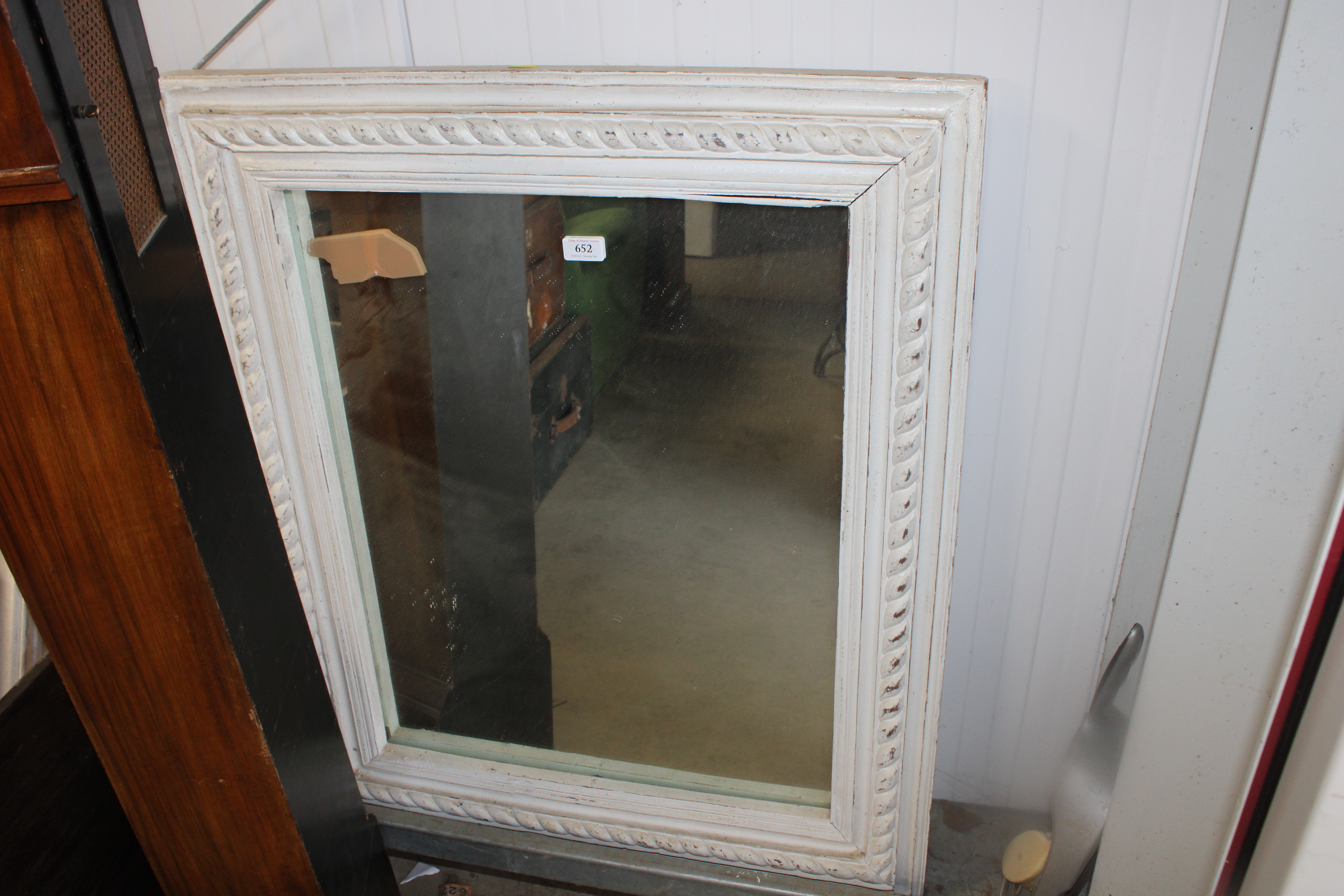 A white painted and ornate framed wall mirror