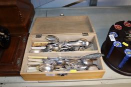 A wooden box containing various silver plated and
