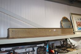 A pierced brass fire fender